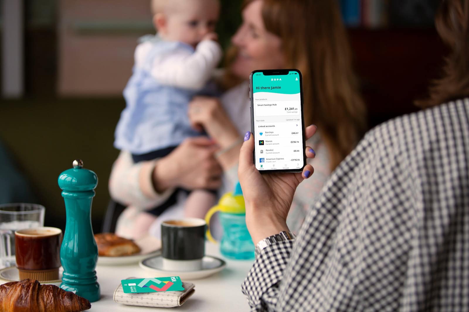 Woman holding phone with Zopa Bank app homesceen on display